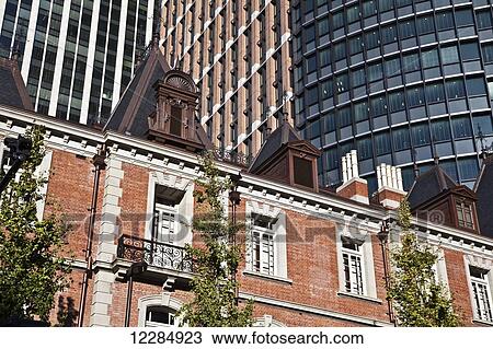 Stock Image - Residential building and trees with skyscrapers behind; Tokyo, Japan. Fotosearch