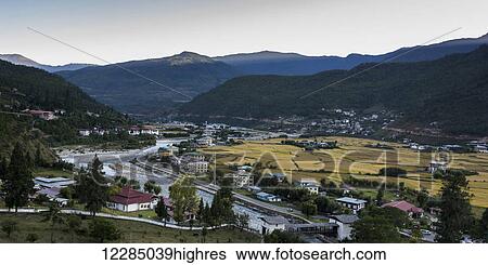 Stock Photograph - River and buildings in the Paro Valley; Paro, Bhutan. Fotosearch