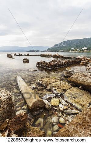 Stock Photograph - Rock and debris along the shoreline; Corinth, Greece. Fotosearch