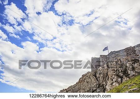 Rock cliff, stone walls and a greek flag; Athens, Greece View Large Photo Image Stock Photograph - Rock cliff, stone walls and a greek flag; Athens, Greece. Fotosearch