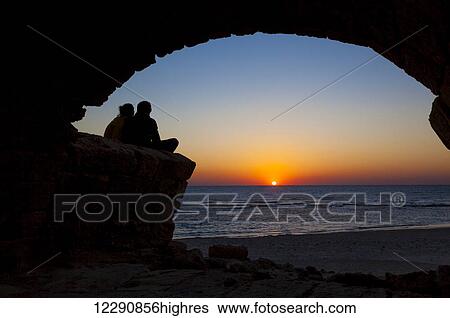 Stock Photograph - Roman aqueduct with arches at sunset in Caesarea Maritima National Park; Israel. Fotosearch