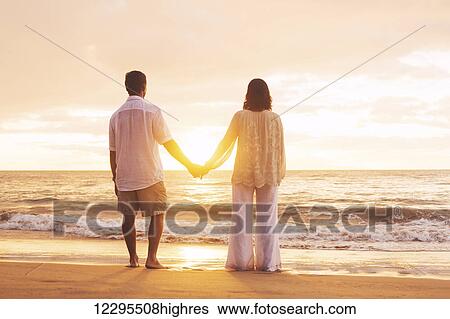 Stock Photograph - Romantic Mature Couple Enjoying Sunset at the Beach. Fotosearch