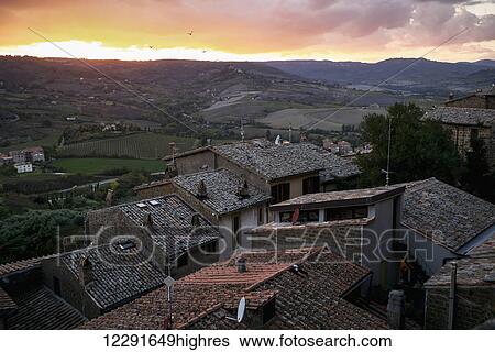 Rooftops of houses in the foreground and rolling hills in the distance at sunset; Orvieto, Umbria, Italy View Large Photo Image Stock Photograph - Rooftops of houses in the foreground and rolling hills in the distance at sunset; Orvieto, Umbria, Italy. Fotosearch