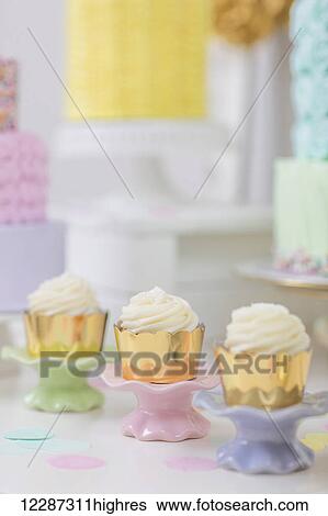 Stock Photograph - Rows of cupcakes on dessert table; Toronto, Ontario, Canada. Fotosearch