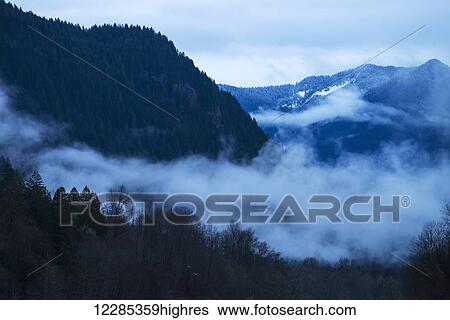 Scenic view of fog amongst the forest and mountains of the North Cascades National Park, Washington, USA View Large Photo Image Stock Photograph - Scenic view of fog amongst the forest and mountains of the North Cascades National Park, Washington, USA. Fotosearch