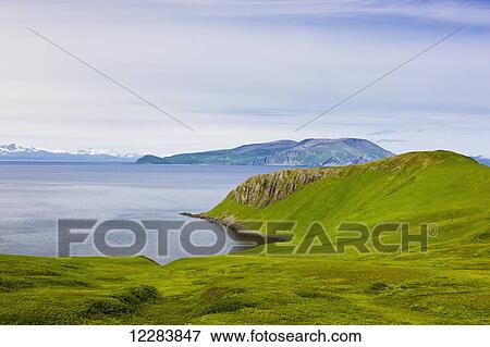 Stock Photo - Scenic view of the green bluffs along the shore of Popof Island near Sand Point, Southwestern Alaska, USA, Summer. Fotosearch