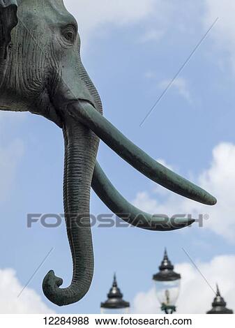 Sculpture of an elephant with tusks and lamp posts in the background; Bangkok, Thailand View Large Photo Image Stock Photo - Sculpture of an elephant with tusks and lamp posts in the background; Bangkok, Thailand. Fotosearch