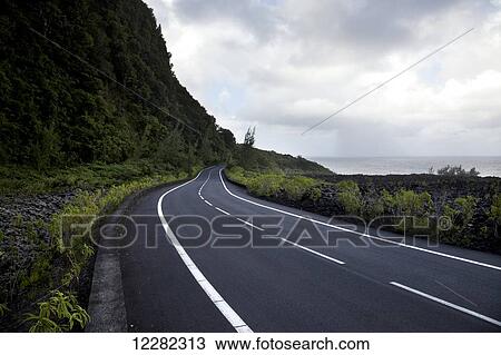 Seafront road under a dramatic sky; Reunion Island, France View Large Photo Image Stock Image - Seafront road under a dramatic sky; Reunion Island, France. Fotosearch