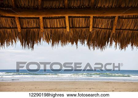 Stock Photograph - Shaded shelter with straw top in Playa Hermosa; Nicaragua. Fotosearch