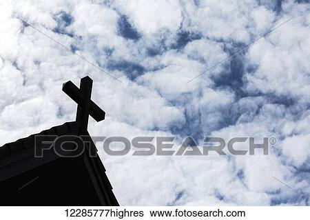 Silhouette of cross on church roof peak with fluffy clouds and blue sky; Calgary, Alberta, Canada View Large Photo Image Stock Photograph - Silhouette of cross on church roof peak with fluffy clouds and blue sky; Calgary, Alberta, Canada. Fotosearch