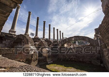 Stock Photograph - Site of ancient ruins with columns and an arch; Smyrna, Turkey. Fotosearch