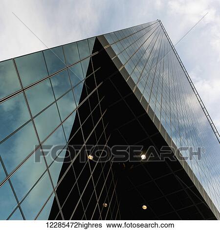 Stock Photograph - Skyscraper with glass walls reflecting the sky; Dallas, Texas, United States of America. Fotosearch