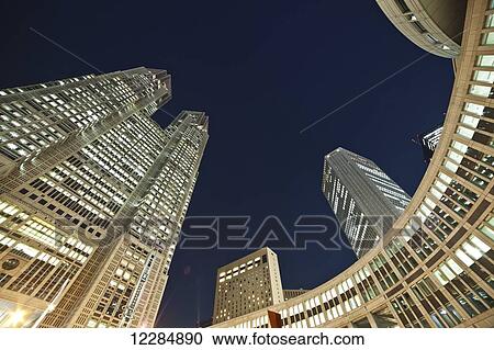 Stock Image - Skyscrapers illuminated at nighttime; Tokyo, Japan. Fotosearch