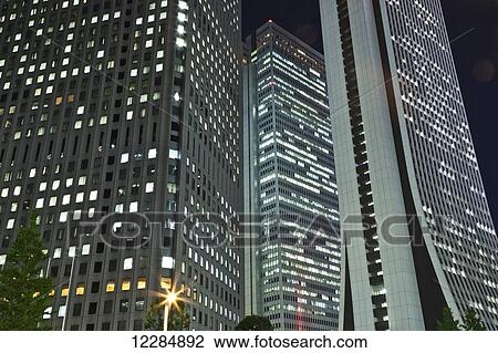 Stock Image - Skyscrapers illuminated at nighttime; Tokyo, Japan. Fotosearch