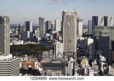 Stock Photo - Skyscrapers in a dense city with blue sky; Tokyo, Japan. Fotosearch