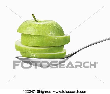 Slices of a cut green apple in a spoon against a white background; Toronto, Ontario, Canada View Large Photo Image Stock Photograph - Slices of a cut green apple in a spoon against a white background; Toronto, Ontario, Canada. Fotosearch
