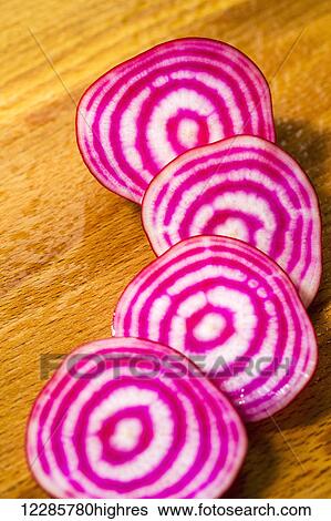 Stock Photograph - Slices of red and white striped beets on wooden cutting board; Calgary, Alberta, Canada. Fotosearch