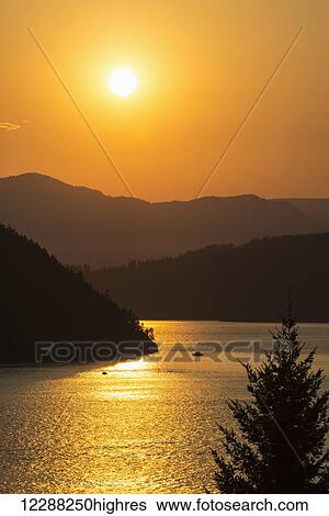 Stock Photograph - Smoke from BC wildfires adds colour to the sunset over Howe Sound; British Columbia, Canada. Fotosearch