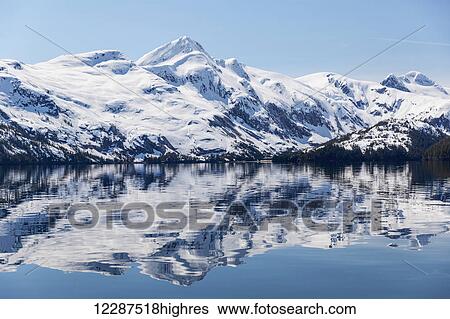 Snow covered mountains reflect in the calm waters of Prince William Sound in winter, Kings Bay; Alaska, United States of America View Large Photo Image Stock Photograph - Snow covered mountains reflect in the calm waters of Prince William Sound in winter, Kings Bay; Alaska, United States of America. Fotosearch