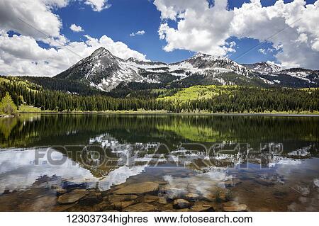 Stock Photograph - Snowcapped East Beckwith mountain in the background reflected in Lost Lake Slough; Colorado, United States of America. Fotosearch
