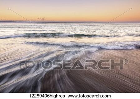 Stock Photograph - Soft ocean waves at Olowalu sunrise; Maui, Hawaii, United States of America. Fotosearch