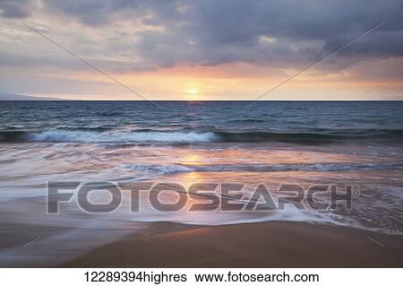 Stock Photograph - Soft ocean waves at sunset from Kamaole Beach; Maui, Hawaii, United States of Amerida. Fotosearch