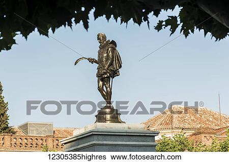 Stock Photograph - Statue and buildings in downtown Alcala de Henares, Cervantes Square, a historical and charming city near to Madrid; Alcala de Henares, Spain. Fotosearch