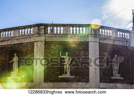 Statues in niches on a brick wall with balustrades along the top with sunlight streaming down, Piazza del Quirinale; Rome, Italy View Large Photo Image Stock Photograph - Statues in niches on a brick wall with balustrades along the top with sunlight streaming down, Piazza del Quirinale; Rome, Italy. Fotosearch