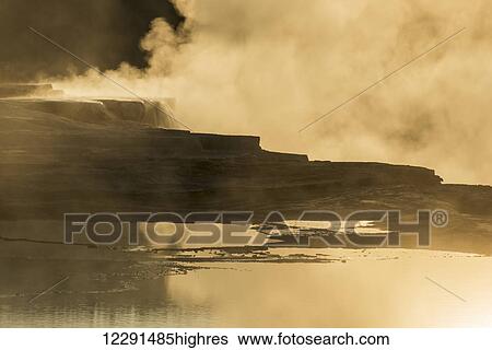 Stock Photograph - Steam in morning light at the Mammoth Hot Spring Terraces in Yellowstone National Park; Wyoming, United States of America. Fotosearch