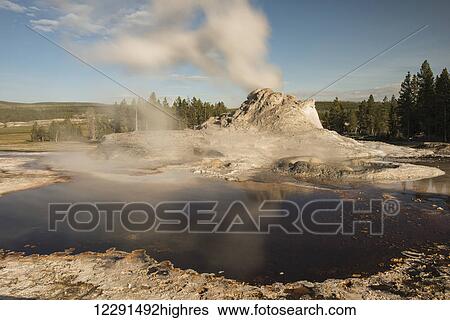 Stock Photograph - Steam rises from the Steamboat Geyser in Yellowstone National Park; Wyoming, United States of America. Fotosearch