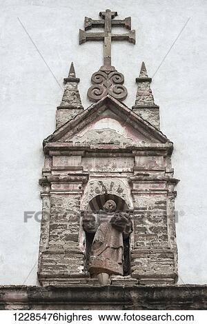Stock Photograph - Stone sculpture of a man standing in a doorway of a building; San Miguel de Allende, Guanajuato, Mexico. Fotosearch