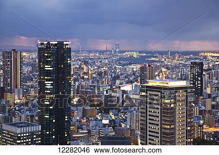 Storm clouds over a city illuminated with lights; Osaka, Japan View Large Photo Image Stock Photograph - Storm clouds over a city illuminated with lights; Osaka, Japan. Fotosearch
