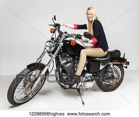 Studio image of a young woman on a motorcycle; Edmonton, Alberta, Canada View Large Photo Image Stock Photograph - Studio image of a young woman on a motorcycle; Edmonton, Alberta, Canada. Fotosearch