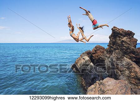 Summer fun, Friends cliff jumping into the ocean. View Large Photo Image Stock Photograph - Summer fun, Friends cliff jumping into the ocean.. Fotosearch