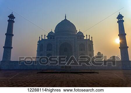 Sun rising behind one of the minarets of the Taj Mahal without a cloud in the sky; Agra, Uttar Pradesh, India View Large Photo Image Stock Photograph - Sun rising behind one of the minarets of the Taj Mahal without a cloud in the sky; Agra, Uttar Pradesh, India. Fotosearch