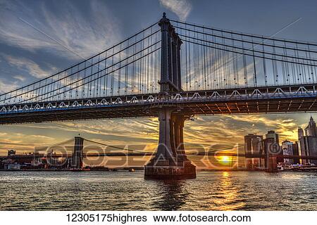 Sun setting behind Manhattan and Brooklyn Bridges; New York City, New York, United States of America View Large Photo Image Stock Photograph - Sun setting behind Manhattan and Brooklyn Bridges; New York City, New York, United States of America. Fotosearch