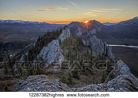 Stock Photograph - Sunset as seen from the top of Sapper Hill along the Dempster Highway, northern Yukon; Yukon, Canada. Fotosearch