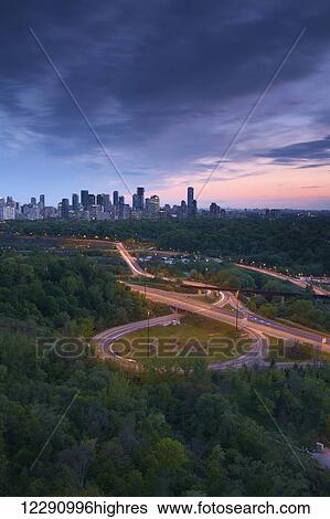 Stock Photograph - Sunset looking south over the Don Valley, Bloor on-ramp, Toronto skyline and Don Valley Parkway; Toronto, Ontario, Canada. Fotosearch