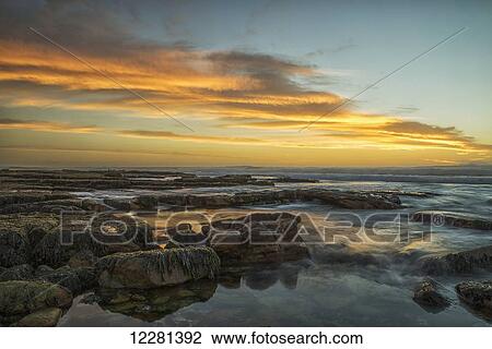 Stock Image - Sunset over the ocean near the city of Cape Town; South Africa. Fotosearch