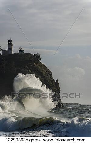 Stock Photograph - Surf breaks at Cape Disappointment Lighthouse; Ilwaco, Washington, United States of America. Fotosearch