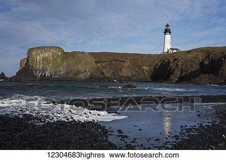Stock Photograph - Surf breaks on the beach near Yaquina Head Lighthouse on the Oregon Coast; Newport, Oregon, United States of America. Fotosearch
