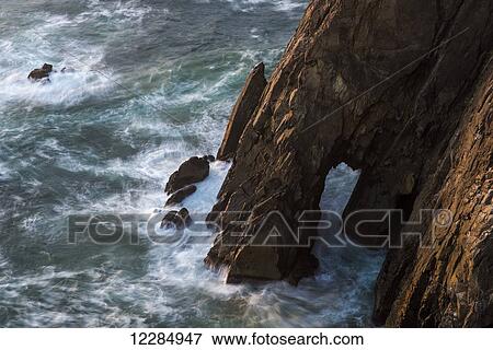 Surf swirls around the base of the cliffs; Manzanita, Oregon, United States of America View Large Photo Image Stock Photo - Surf swirls around the base of the cliffs; Manzanita, Oregon, United States of America. Fotosearch