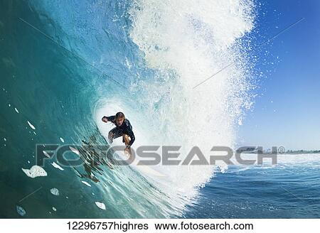 Stock Photograph - Surfer on Blue Ocean Wave in the Tube Getting Barreled. Fotosearch