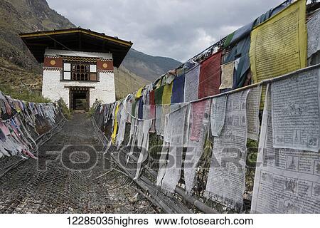 Stock Photograph - Suspension bridge made from wood and chain across Paro river, near Tachog Lhakhang Dzong; Paro, Bhutan. Fotosearch