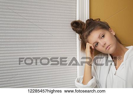 Teenage girl resting her head on her hand View Large Photo Image Stock Photograph - Teenage girl resting her head on her hand. Fotosearch