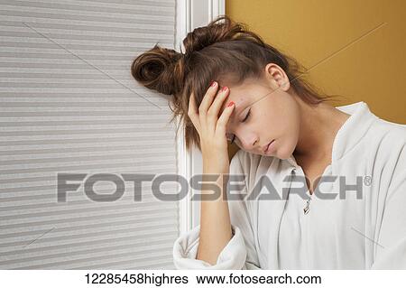 Stock Photograph - Teenage girl resting her head on her hand. Fotosearch