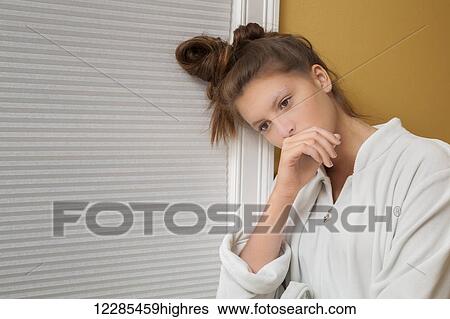 Stock Photograph - Teenage girl resting her head on her hand. Fotosearch