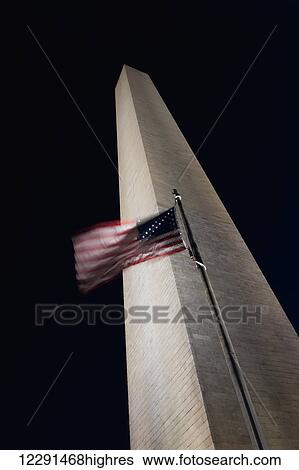 Stock Photograph - The American flag flies in a stiff wind at the Washington Monument; Washington, District of Columbia, United States of America. Fotosearch