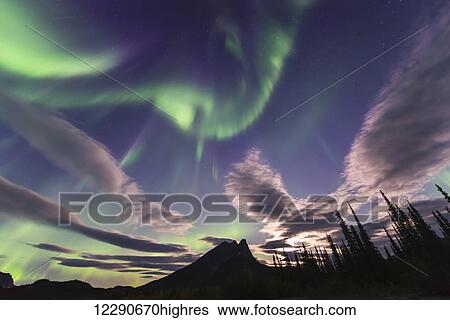 The aurora borealis and clouds share the sky over Mt. Sukakpak in the Brooks Range north of Wiseman, Arctic Alaska. View Large Photo Image Stock Photograph - The aurora borealis and clouds share the sky over Mt. Sukakpak in the Brooks Range north of Wiseman, Arctic Alaska.. Fotosearch