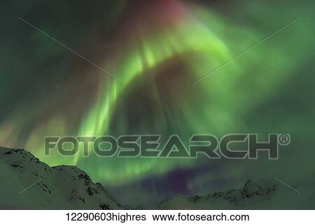 Stock Photograph - The aurora borealis towers over the Talkeetna Mountains in Hatcher Pass State Recreation Area, Alaska.. Fotosearch